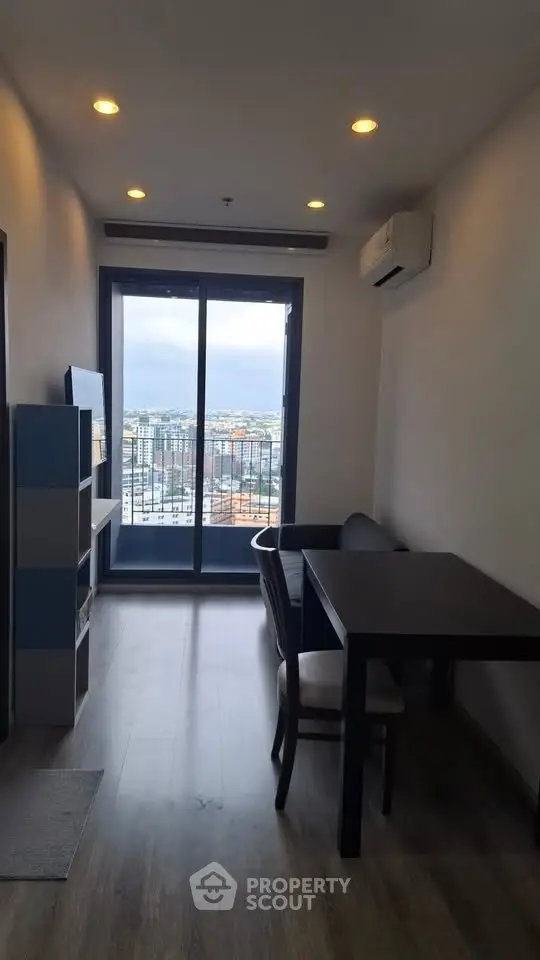 Modern living room with city view, featuring sleek furniture and large windows for natural light.
