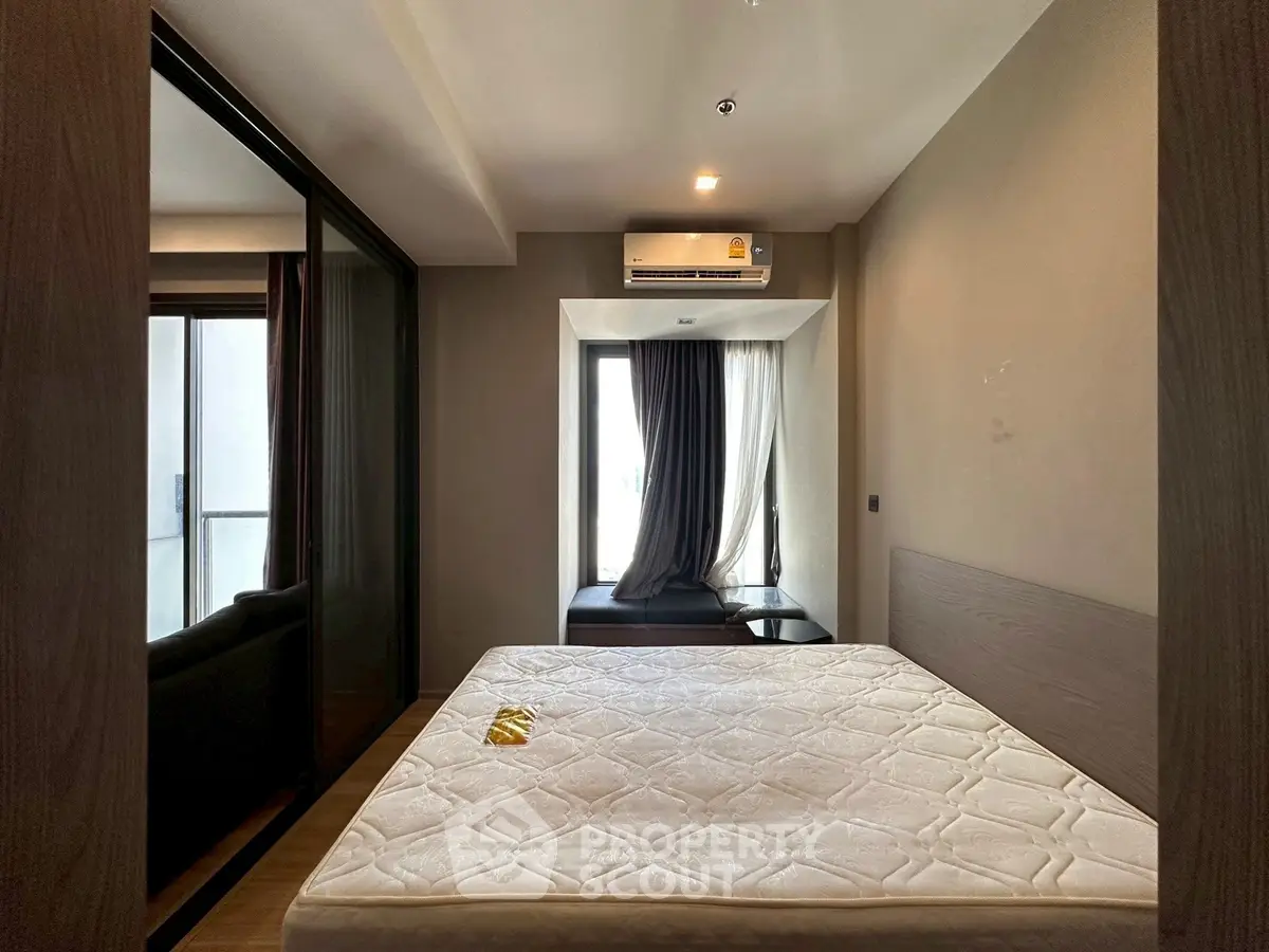 Modern bedroom with large window and air conditioning in a stylish apartment.