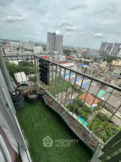 High-rise balcony with city view and small garden planters, perfect urban retreat.