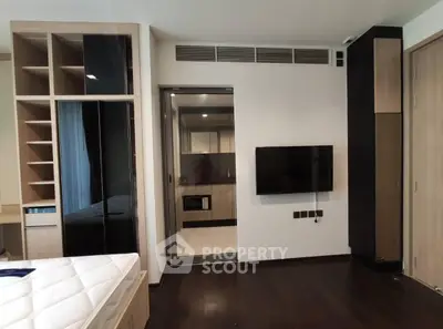 Modern bedroom with sleek design, featuring built-in storage and wall-mounted TV, perfect for urban living.