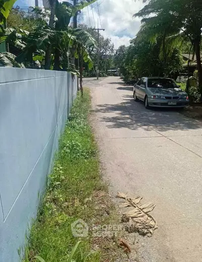 Charming suburban street with lush greenery and parked car, perfect for serene living.