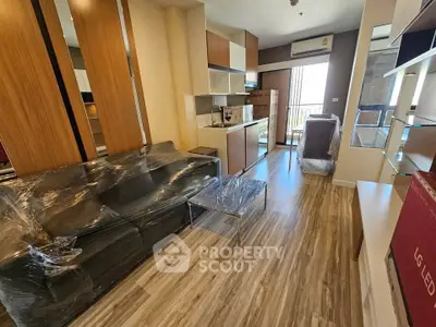 Modern living room with sleek furniture and open kitchen layout in a stylish apartment.
