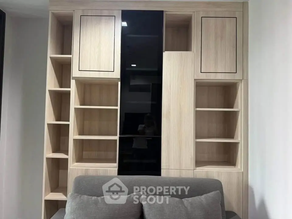 Modern living room with stylish wooden shelving and cozy gray sofa