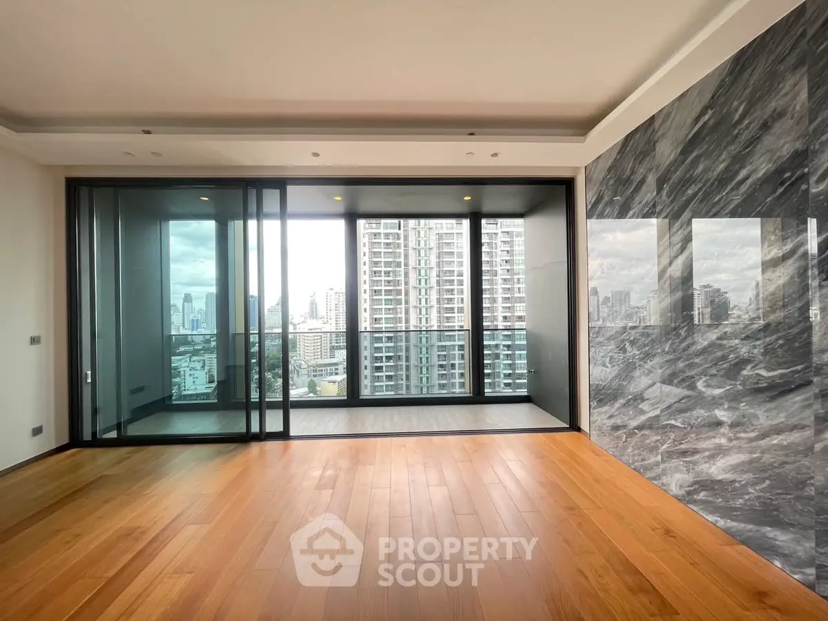 Spacious modern living room with stunning city view and elegant wooden flooring.