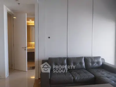 Modern living room with sleek gray sofa and glimpse of stylish bathroom