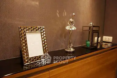 Elegant interior decor with stylish frame and sculpture on a wooden console, perfect for modern living spaces.