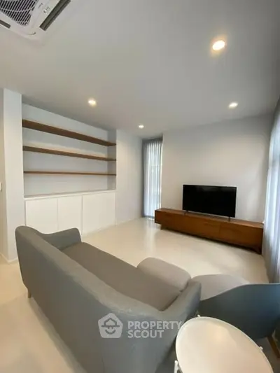 Modern living room with sleek furniture and built-in shelving