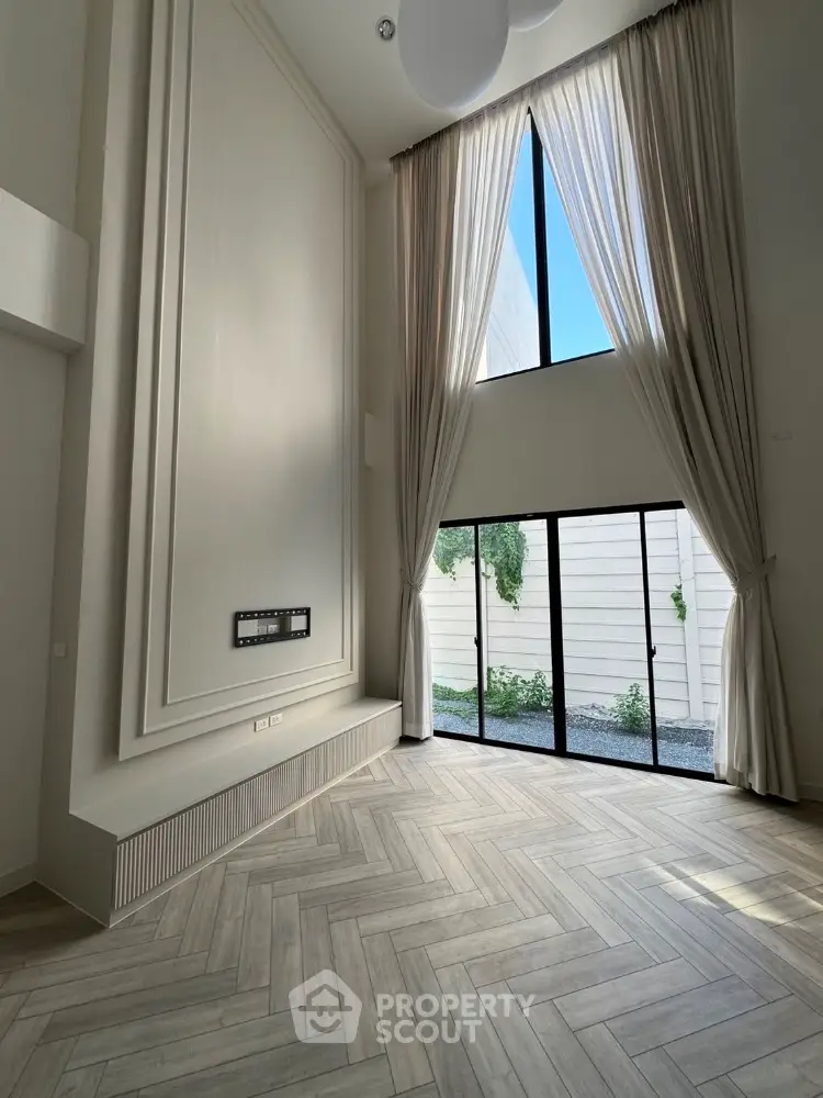Spacious modern living room with high ceilings and large windows