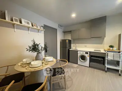 Modern kitchen with dining area, featuring sleek appliances and stylish decor.