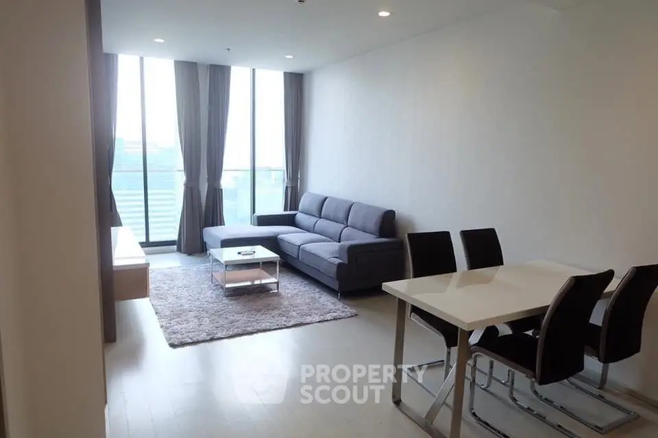 Modern living room with sleek furniture and large windows offering natural light.