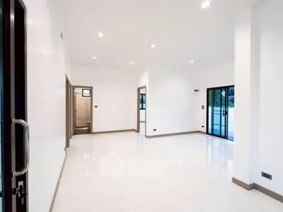 Spacious modern living room with large windows and sleek white flooring