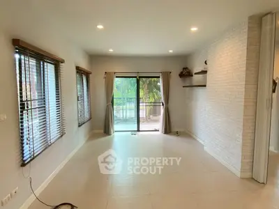 Spacious living room with large windows and balcony access, perfect for natural light and outdoor views.