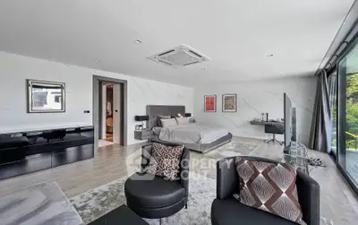 Luxurious modern bedroom with stylish decor and large windows overlooking greenery.