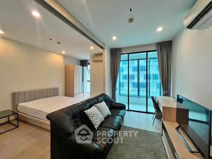 Modern studio apartment with open layout and balcony view