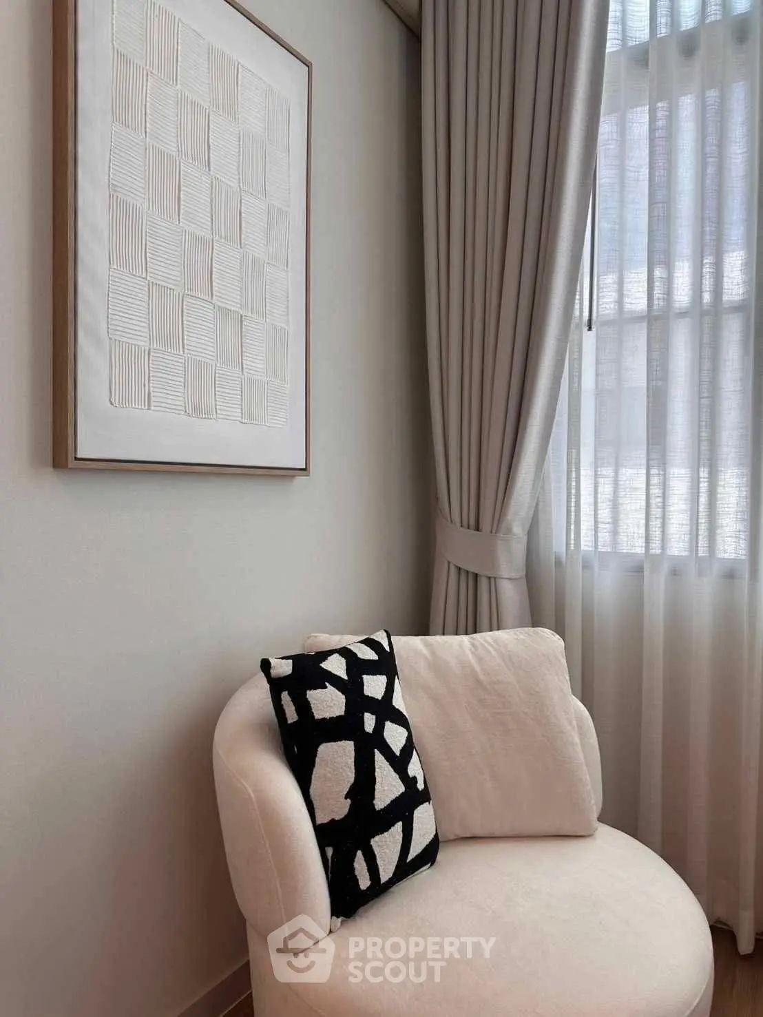 Elegant corner with plush chair and modern art in a cozy living room setting.