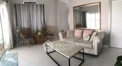 Chic living room with elegant sofa, stylish chairs, and large mirror enhancing space.