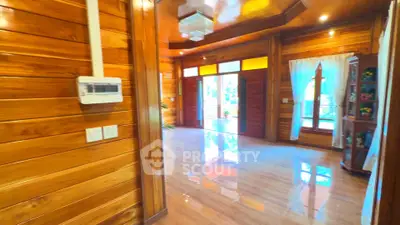 Spacious wooden interior with large windows and polished floors