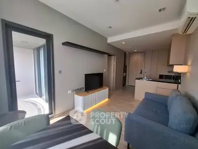 Modern living room with open kitchen and balcony access in a stylish apartment.