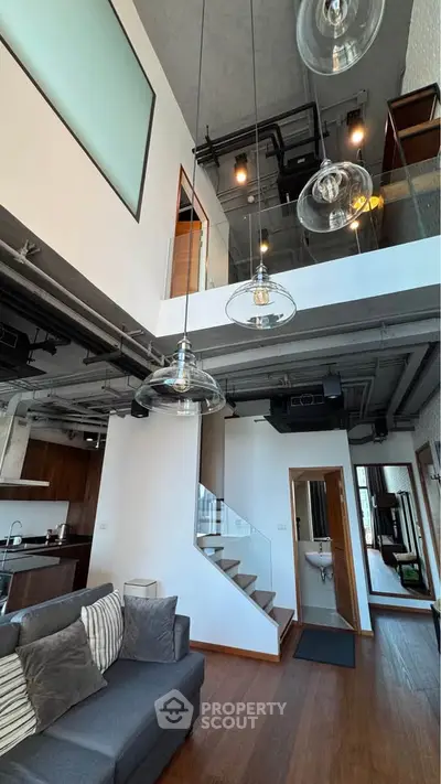 Modern loft apartment with high ceilings, stylish lighting, and open kitchen layout.