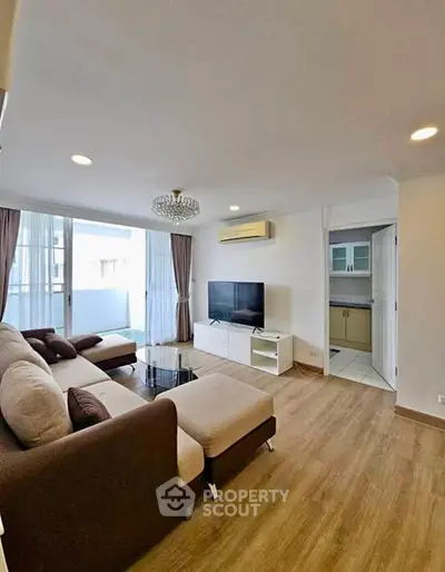 Spacious living room with modern decor and natural light in a stylish apartment.