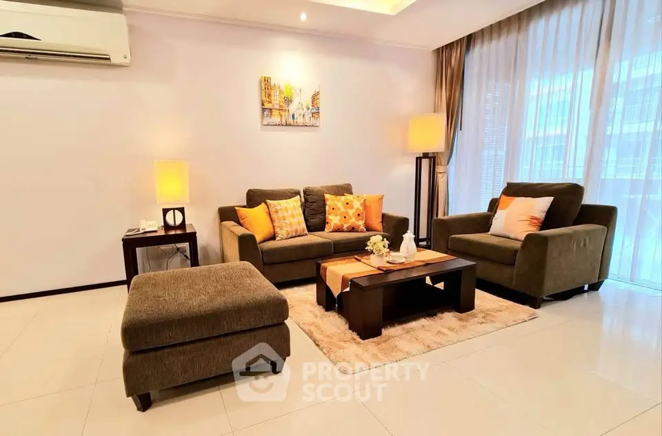 Elegant living room with modern furniture and large windows offering natural light.