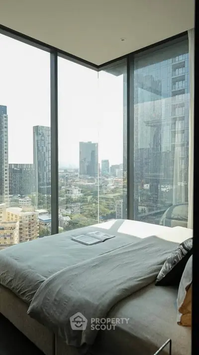 Luxurious bedroom with panoramic city view from floor-to-ceiling windows in modern high-rise.
