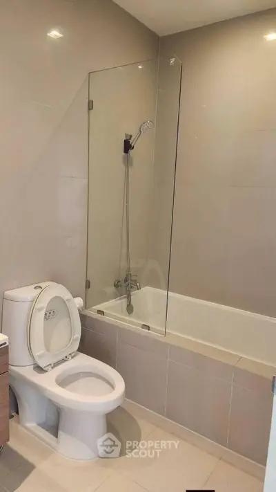 Modern bathroom with sleek bathtub and shower in contemporary apartment.
