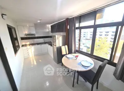 Bright kitchen with dining area and large windows in modern apartment