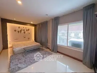 Spacious bedroom with large window and elegant decor in modern home