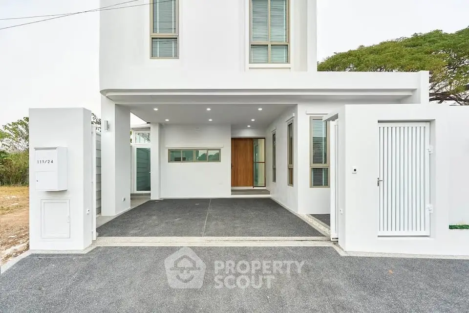 Modern white exterior of a minimalist home with sleek design and spacious driveway.