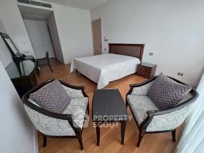 Spacious bedroom with elegant furniture and hardwood flooring