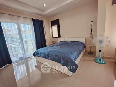 Spacious bedroom with modern decor and large windows for natural light