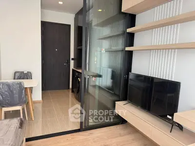 Modern living room with sleek furniture and glass partition in a stylish apartment.