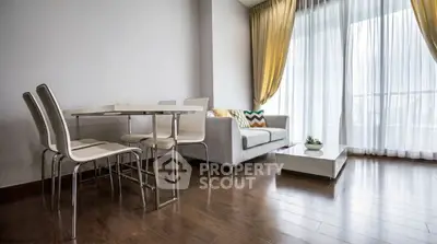 Modern living room with elegant dining set and cozy sofa near large window with curtains.