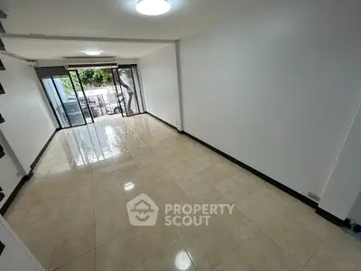 Spacious empty living room with large windows and tiled flooring, ideal for customization.
