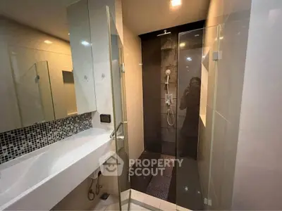 Modern bathroom with sleek shower and stylish sink in contemporary design.