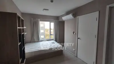 Cozy bedroom with natural light, featuring a comfortable bed and modern air conditioning unit.