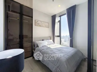Modern bedroom with city view, featuring sleek wardrobe and cozy bedding.