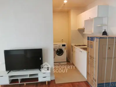 Modern compact living space with kitchen and washing machine, ideal for urban living.