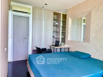 Modern bedroom with sleek design and built-in storage, featuring a cozy workspace.