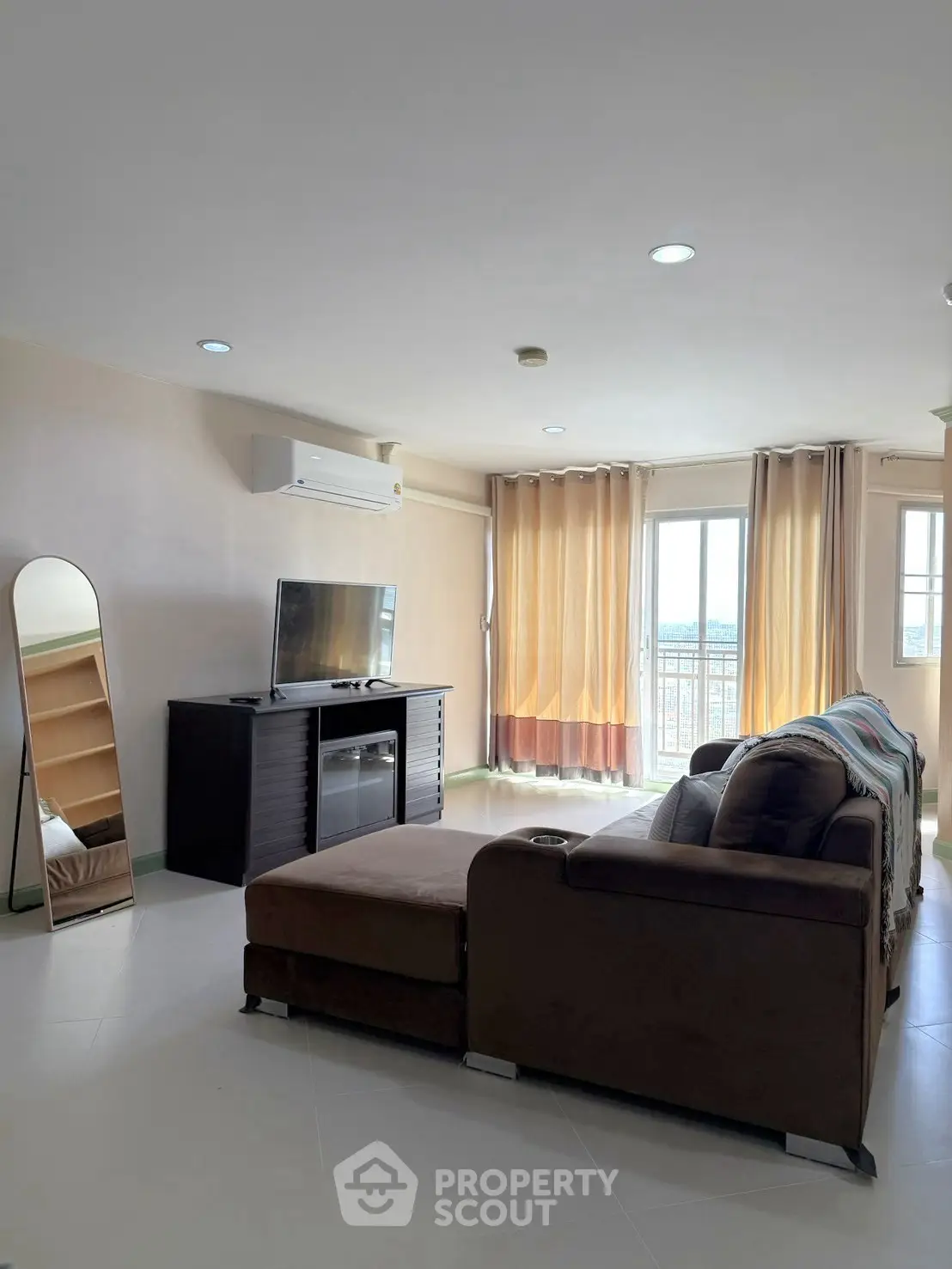 Spacious living room with modern sofa and large windows offering natural light.