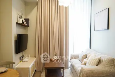 Cozy living room with modern decor, featuring a plush sofa, wall-mounted TV, and elegant curtains.