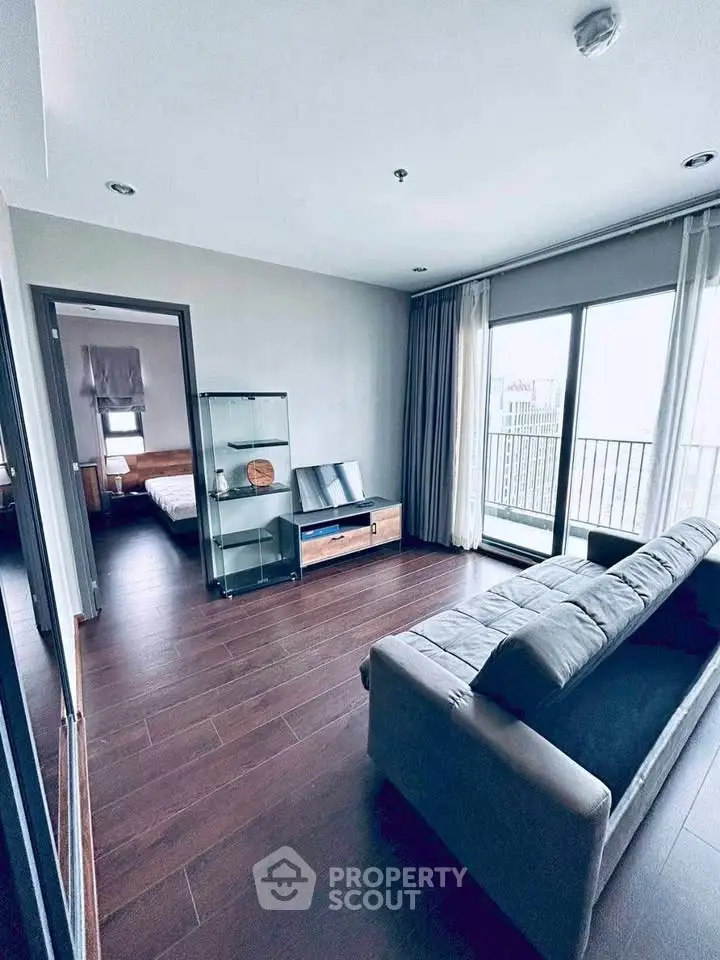 Modern living room with sleek design and balcony access in a stylish apartment.