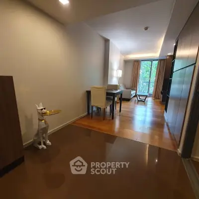 Modern living room with stylish decor and wooden flooring, featuring a unique dog sculpture and large windows.