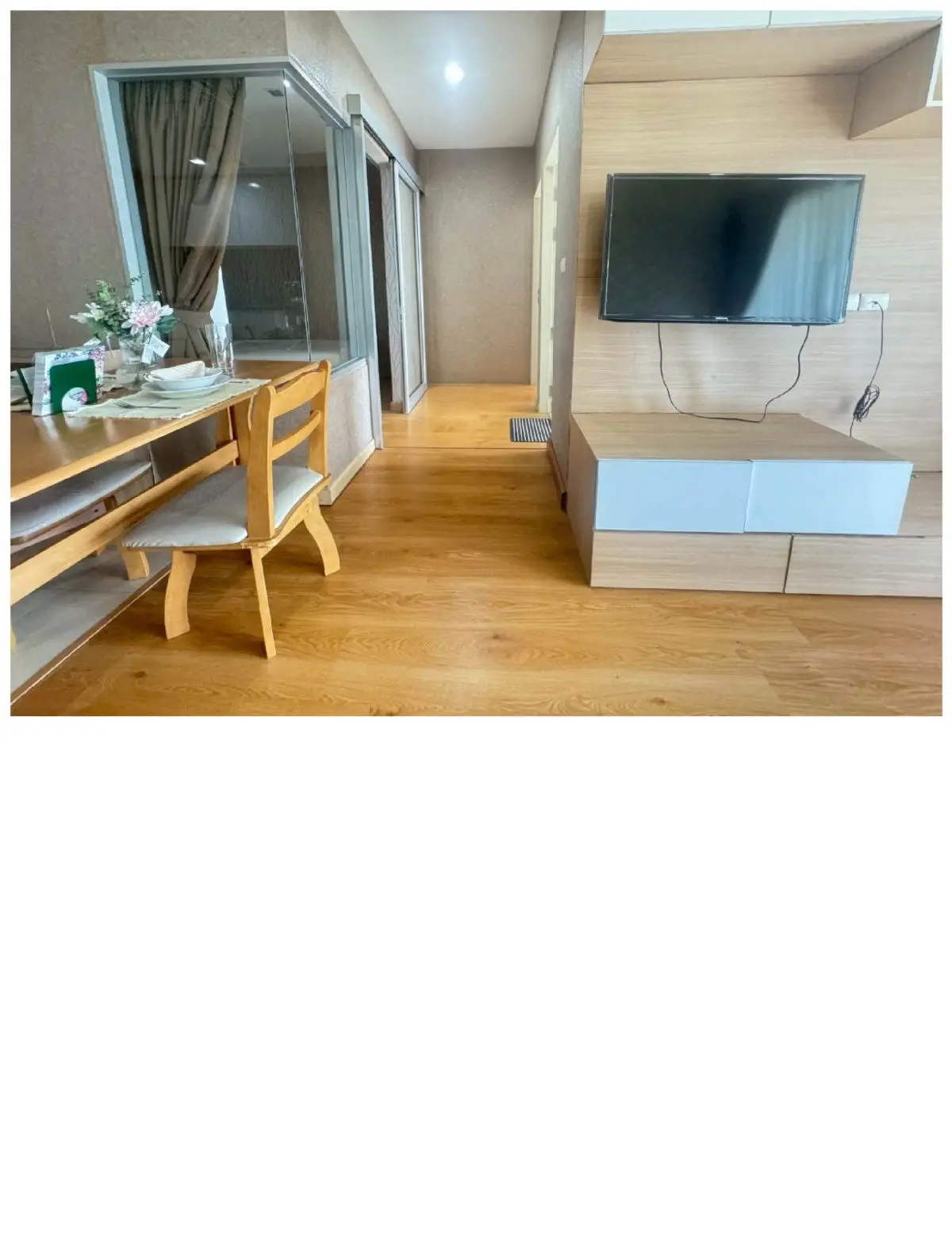 Modern living room with wooden flooring and wall-mounted TV