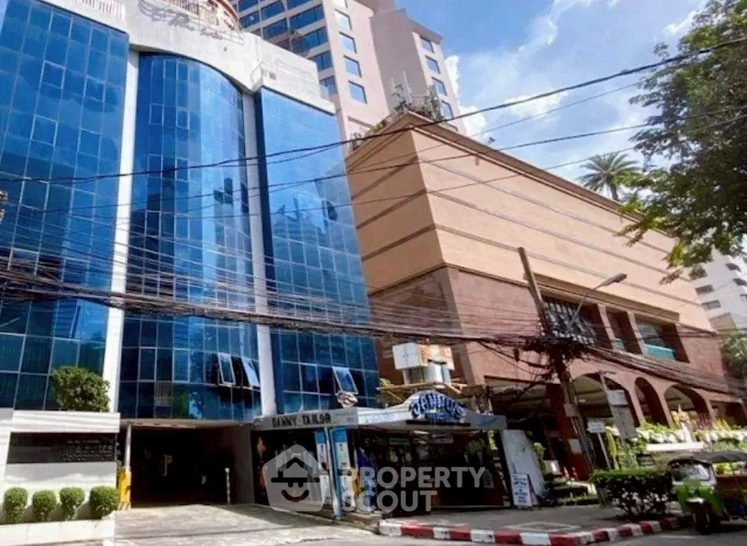 Modern commercial building with glass facade and street view in urban setting.