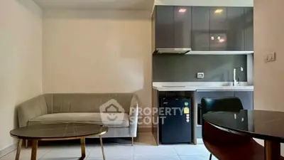 Modern living room with sleek kitchenette and stylish furniture in a cozy apartment.