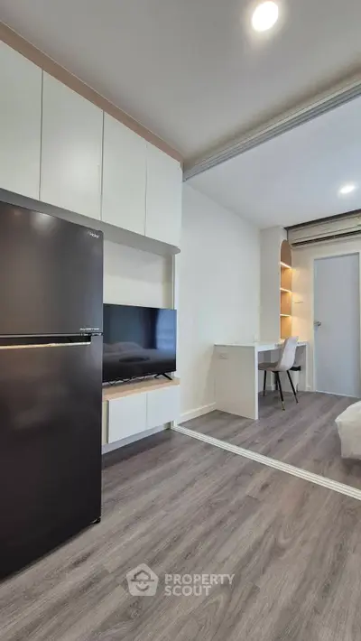 Modern living room with sleek design and integrated kitchen appliances