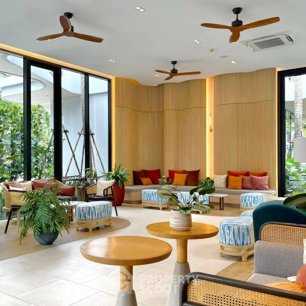 Stylish modern living room with vibrant decor and large windows overlooking greenery.