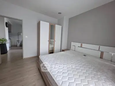 Spacious bedroom with modern design and ample natural light, featuring a comfortable bed and sleek wardrobe.